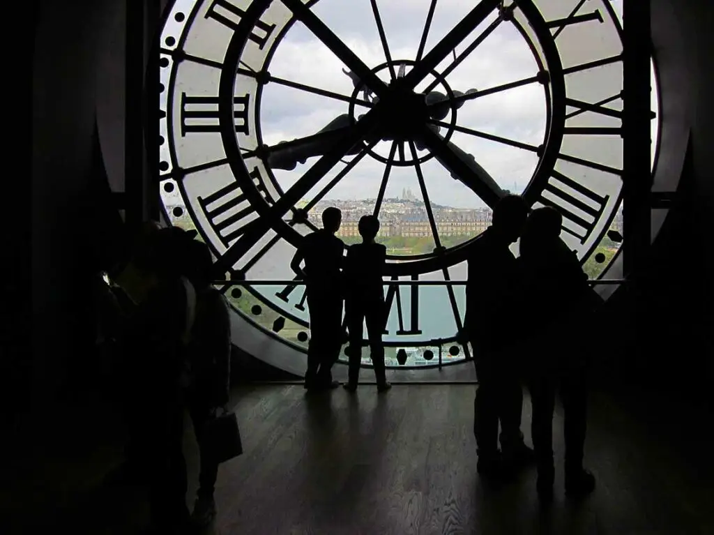 couple looking through glass clockface in Musée d'Orsay,