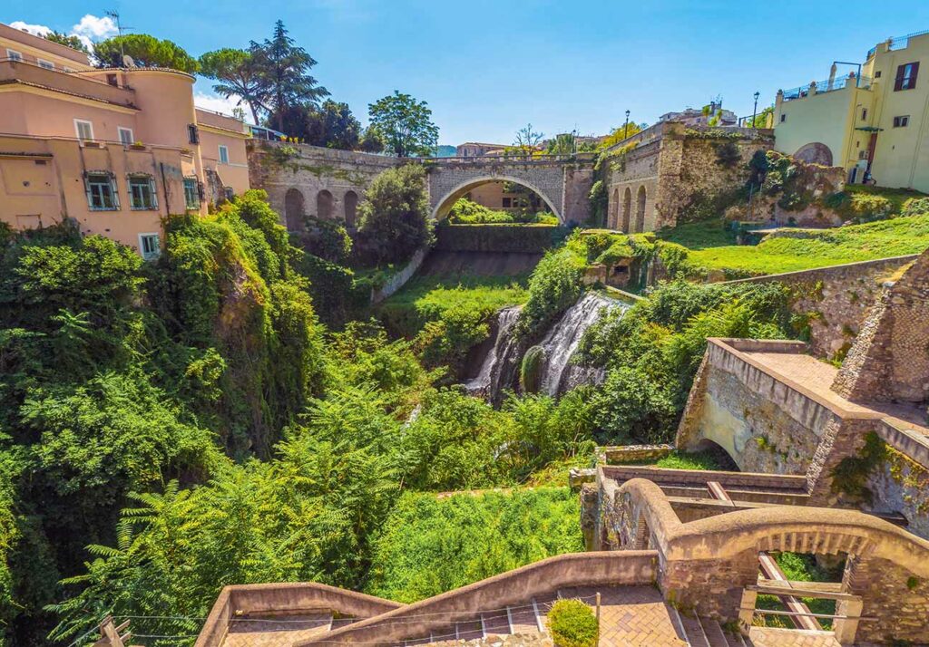 Scenic view of Tivoli's ancient bridges and waterfalls surrounded by lush greenery in Italy