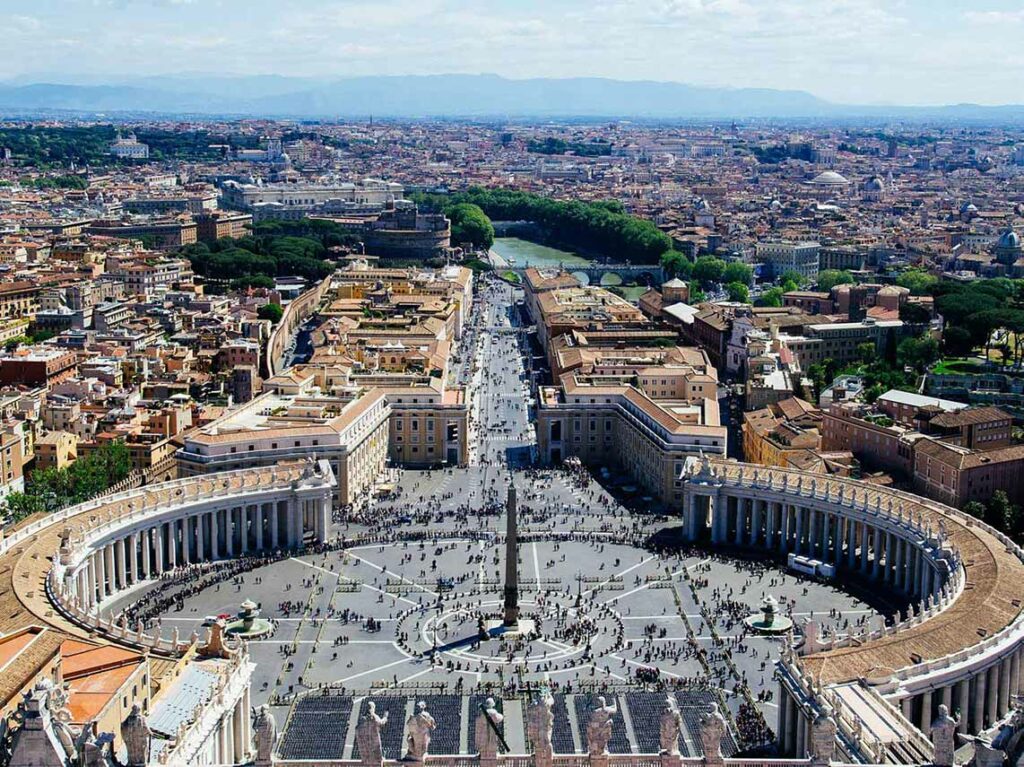 Aerial view of Saint Peter's Square in Vatican City, showing crowds of visitors and the iconic colonnades, perfect for private tours of Rome.