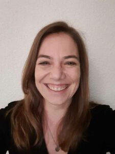 Claudia smiling warmly, a professional tour guide from Luxury France Tours, in a casual setting.