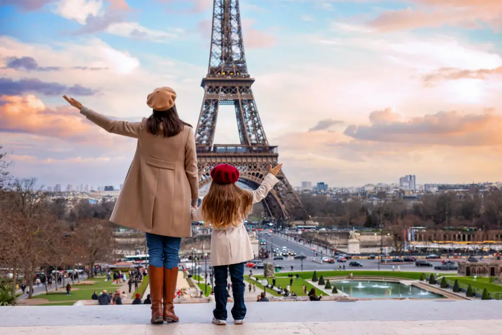 Mother and daughter enjoying a view of the Eiffel Tower in Paris, symbolizing a memorable family vacation in France.