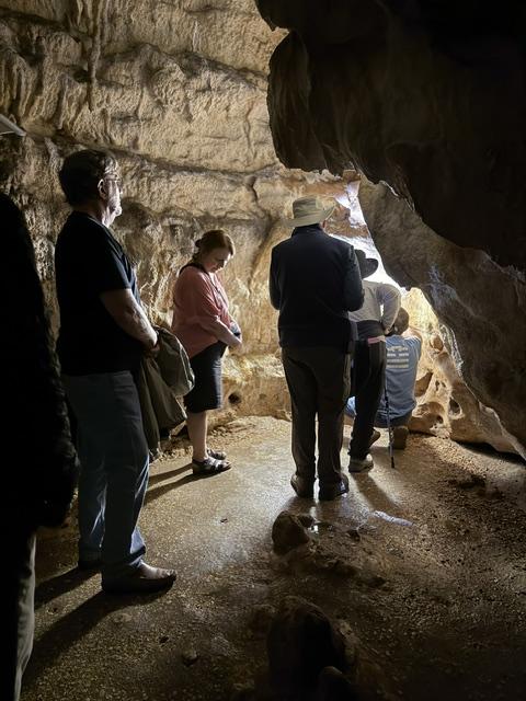 Group exploring a prehistoric cave during their private tour of the Dordogne.