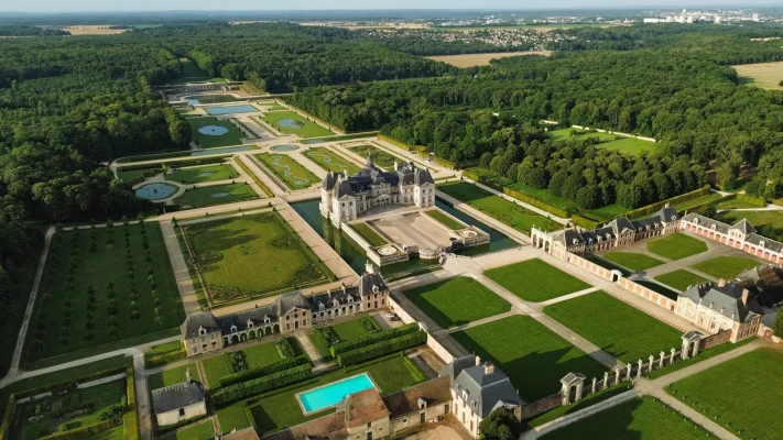 Aerial view of Vaux-le-Vicomte castle in France, showcasing the elaborate gardens and classical French architecture, perfect for luxury tours in Europe.
