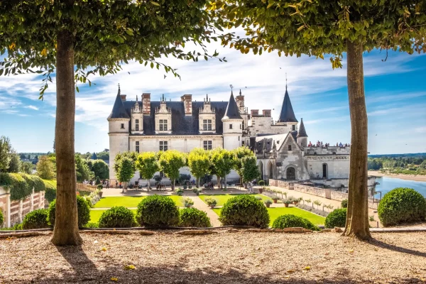 Chateau Amboise framed by lush trees in a Renaissance garden in France, showcasing French heritage and historical architecture.